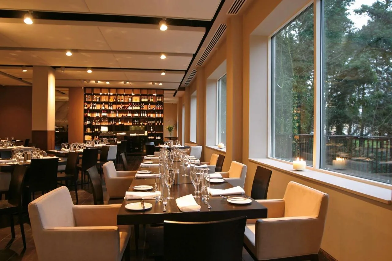 a dining room with a long table and chairs at Park Plaza Cardiff in Cardiff