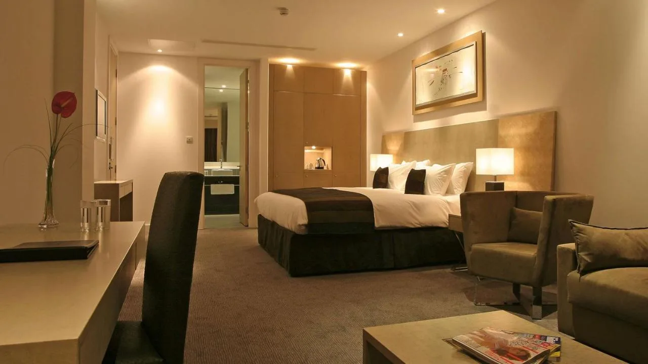 a hotel room with a bed and a living room at Park Plaza Cardiff in Cardiff