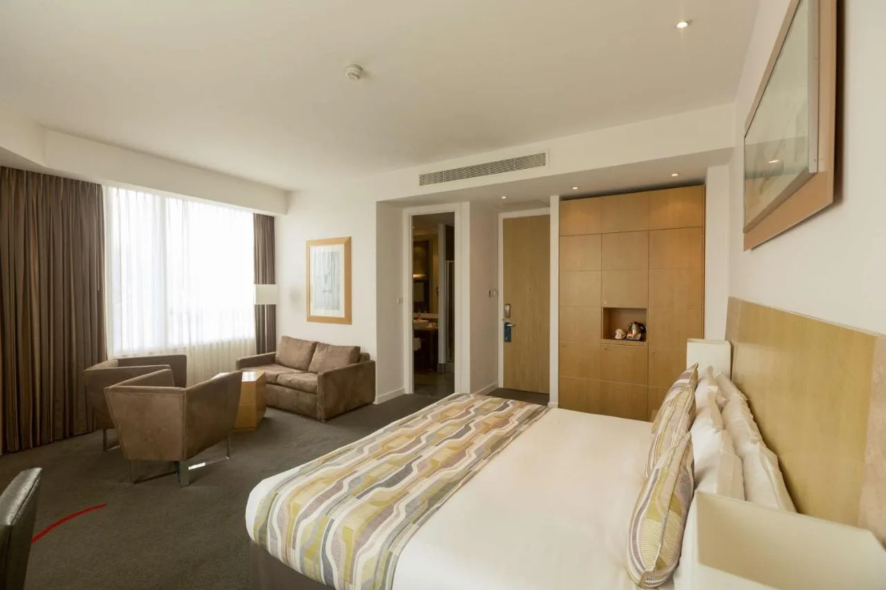 a hotel room with a large bed and a couch at Park Plaza Cardiff in Cardiff
